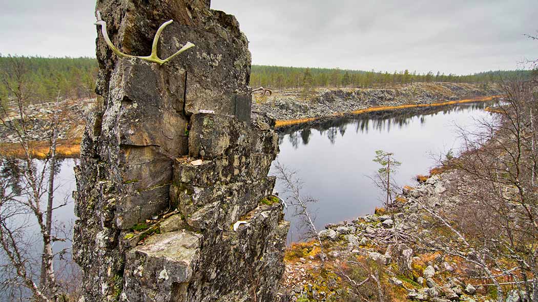 Järven rannalla korkea luonnon kivipatsas.