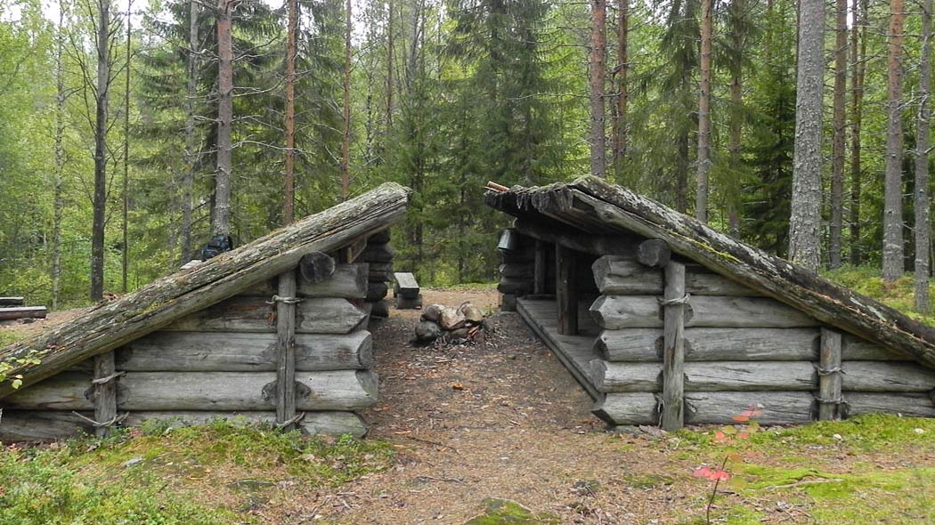 Kaksi laavua vastakkain. Ympärillä metsää.